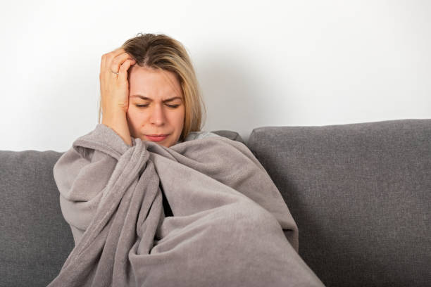 istock Sick woman lying on the couch 1367633336