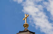 Gold cross on a cathedral roof. Christian crosses on the orthodox church against the background of the blue sky with clouds