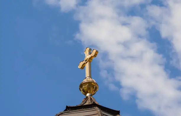 Gold cross on a cathedral roof. Christian crosses on the orthodox church against the background of the blue sky with clouds