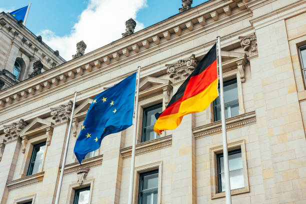 looking up at the flags of the european union and Germany waving in the wind. stock photo
