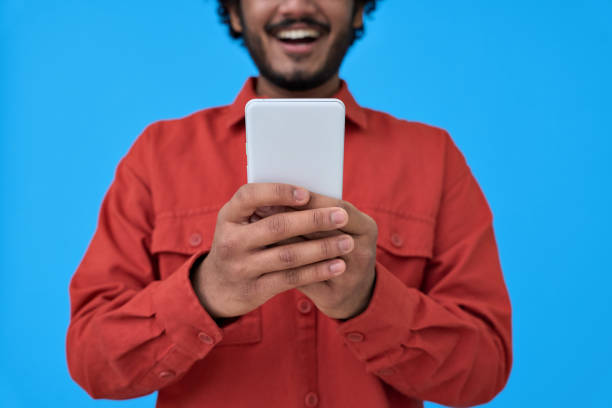 istock Happy young man using cell phone isolated on blue background. closeup 1367646513