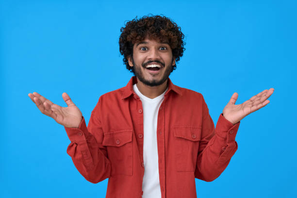 istock Surprised excited young indian man isolated on blue background. 1367646521