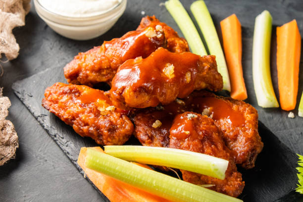 istock Appetizing buffalo chicken wings. In sauce and with fresh celery and carrot sticks. 1367647710