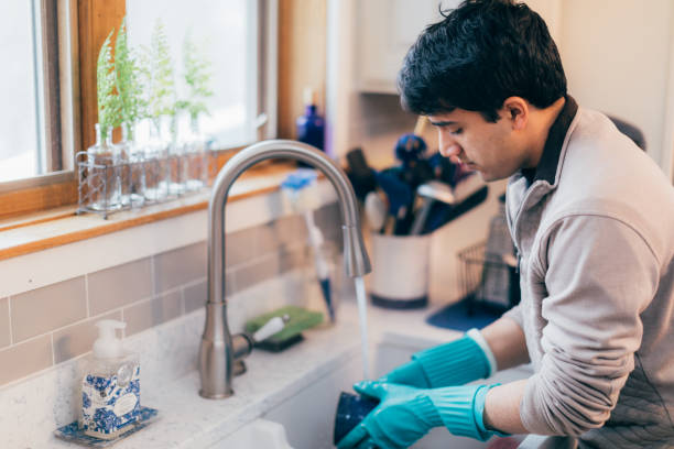 istock Young man cleaning the dishes 1367647751
