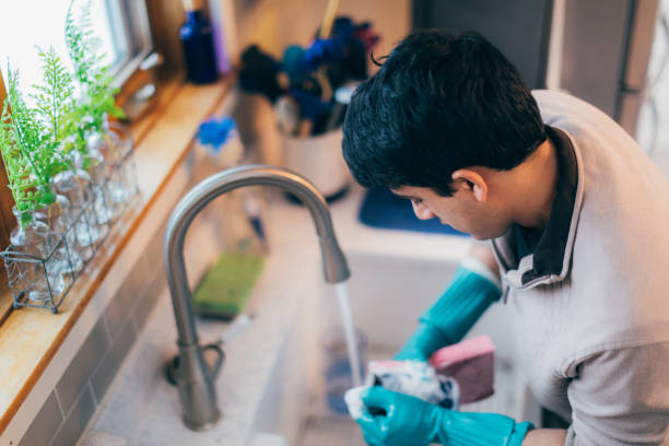 istock Young man cleaning the dishes 1367647757