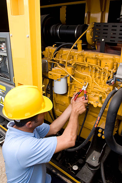 Hard-hatted mechanical technician working on machinery technician is fixing the problem on generator  large machine stock pictures, royalty-free photos & images