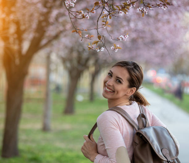 istock Student girl in street under blooming trees 1367653520