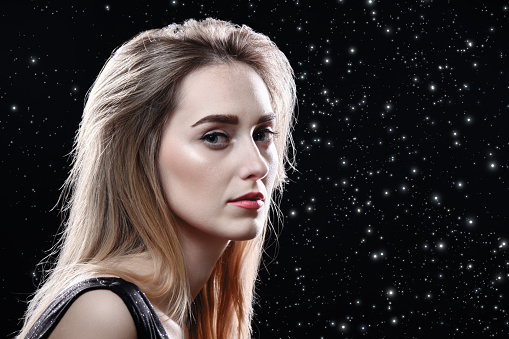 sad young blond woman on stars background with copy space looking at camera