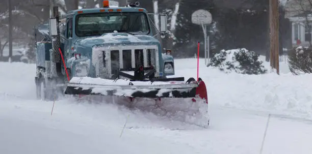 A Babylon village snowplow clearing a residential street during the blizzard of 2022 on Long Island New York.