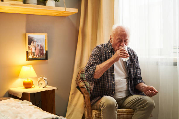 istock Senior man drinking pills in the morning 1367657168