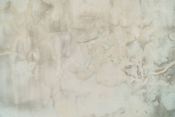 Concept of a plain white plastered brick wall with cracks for backgrounds, patterns and textures for backgrounds. Concrete surfaces are slightly rough.