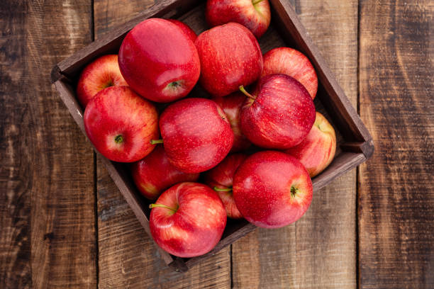 istock Ripe red apples in wooden box. Top view with space for your text. 1367659066