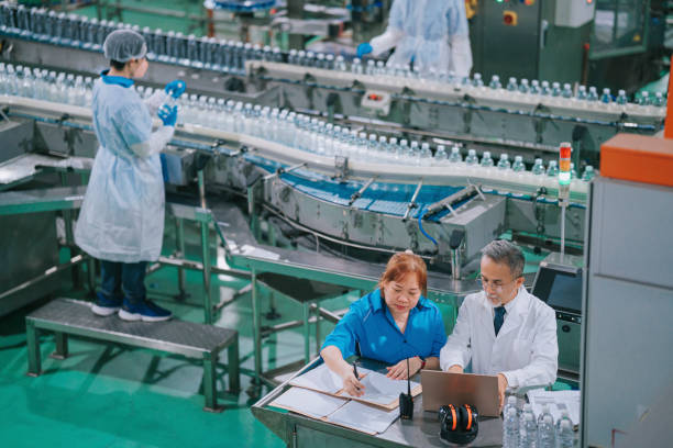 istock Foreperson and manager checking production progress with background drinking water factory production line worker examining water bottle working in daily routine 1367659313