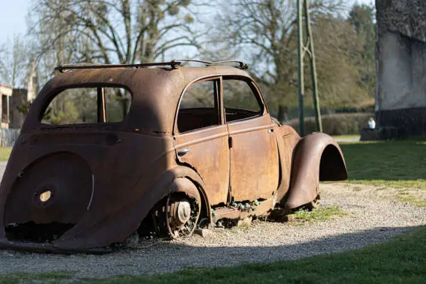 An old abandoned rusty car in a village