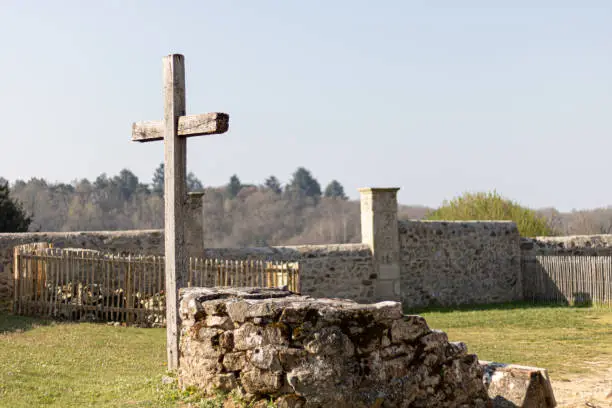 An old wooden cross by the ruins in a village
