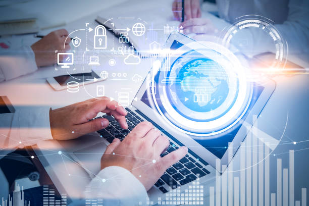 istock Two working business colleagues, taking notes and using laptop, blue and white glowing information protection icons and globe. Padlock, business data symbols. Cyber security and data storage 1367662238