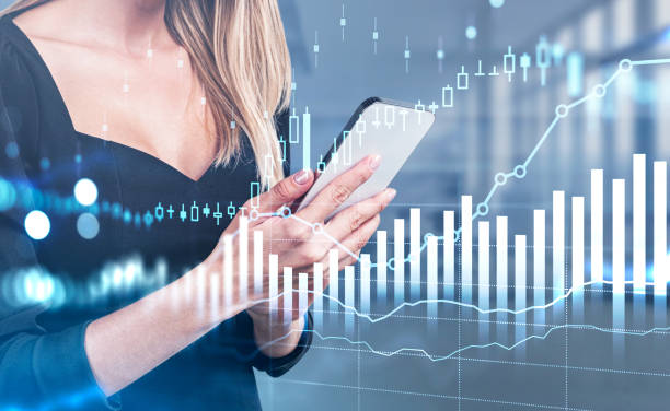 istock Businesswoman with phone in hands, graph changes with candlesticks 1367663563