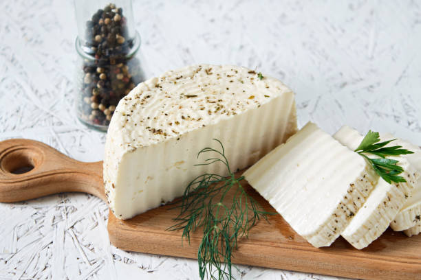 istock White cheese and spices on a wooden board on a white background 1367664072