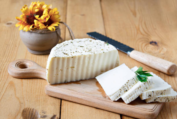istock White cheese and spices on a wooden board on a white background 1367664248