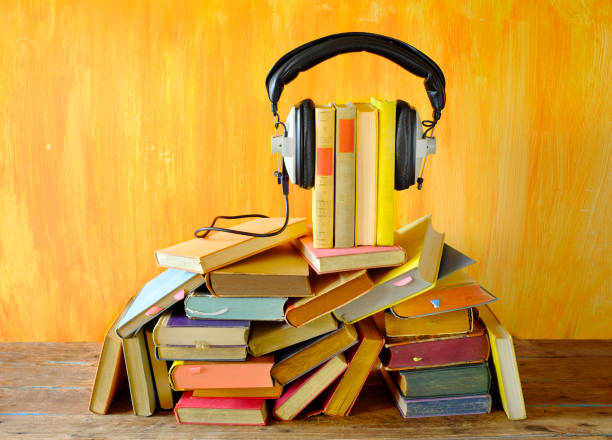 audio book concept with row of books and vintage headphones,literature,entertainment digital book, good copy space stock photo