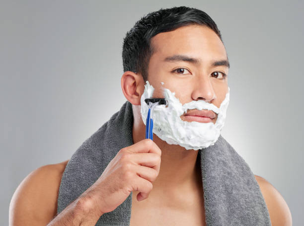 istock Studio shot of a handsome young man shaving against a grey background 1367670373