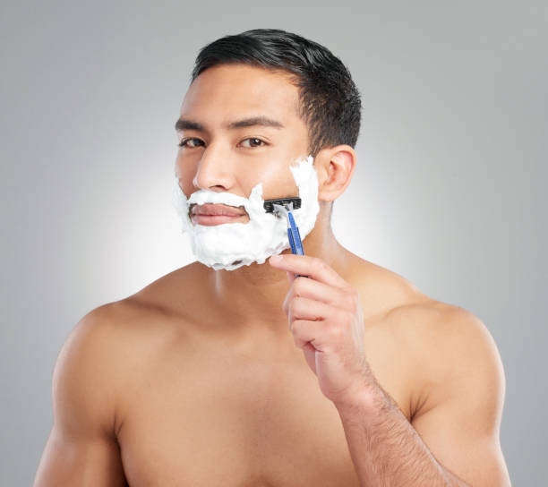 istock Studio shot of a handsome young man shaving against a grey background 1367670374