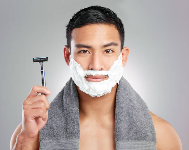 istock Studio shot of a handsome young man shaving against a grey background 1367670375