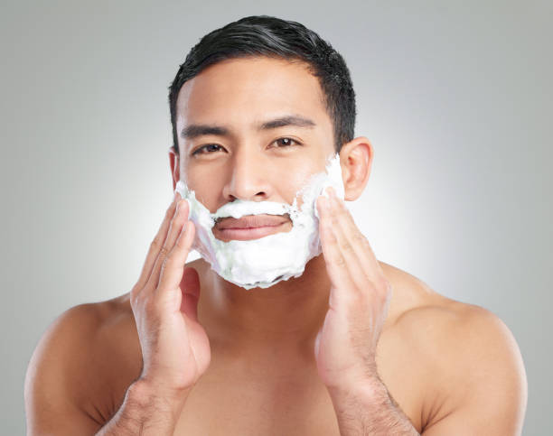 istock Studio shot of a handsome young man shaving against a grey background 1367670376