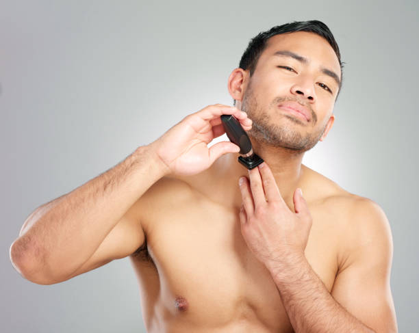 istock Studio shot of a handsome young man shaving against a grey background 1367670377
