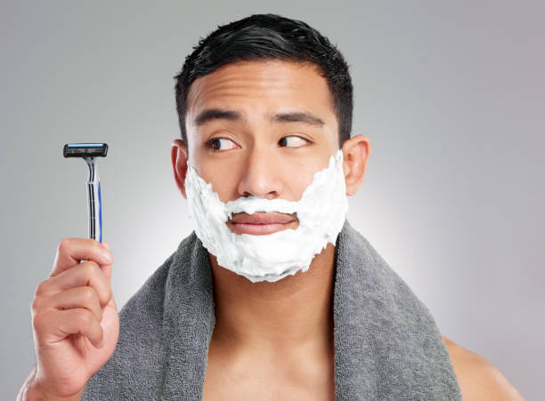 istock Studio shot of a handsome young man shaving against a grey background 1367670381