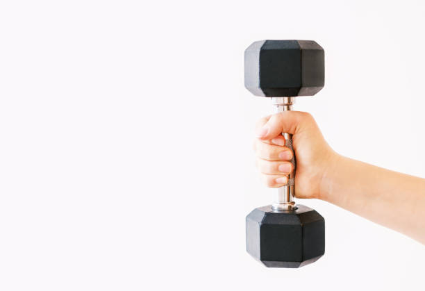 istock Female hand holding an iron dumbbell on white background, copy space. 1367671996