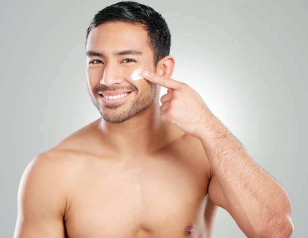 istock Studio shot of a handsome young man applying moisturiser against a grey background 1367673014