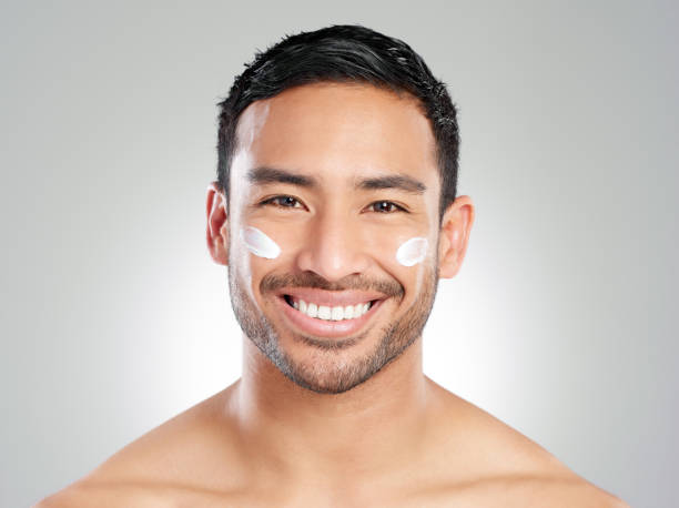 istock Studio shot of a handsome young man applying moisturiser against a grey background 1367673018