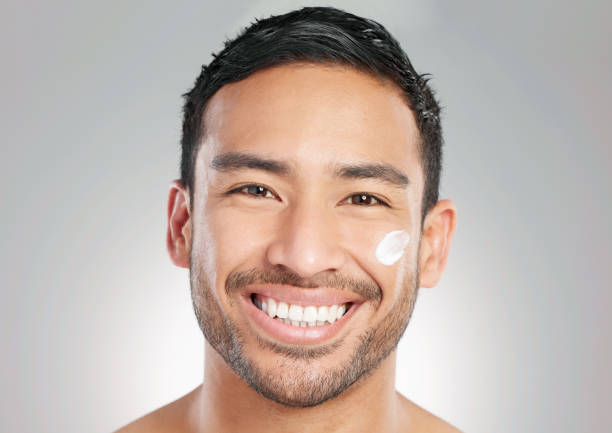 istock Studio shot of a handsome young man applying moisturiser against a grey background 1367673026