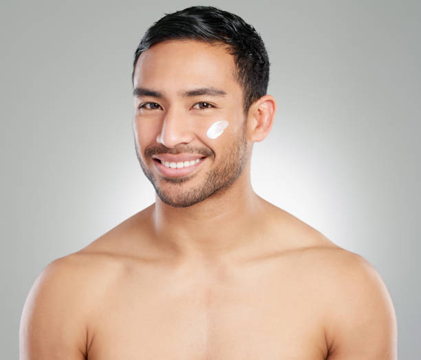 istock Studio shot of a handsome young man applying moisturiser against a grey background 1367673034