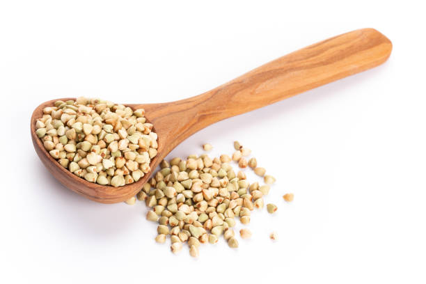 istock Raw buckwheat and wooden spoon on white background. 1367676244