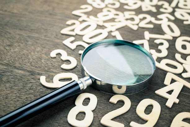 Magnifying glass in scattered numbers stock photo