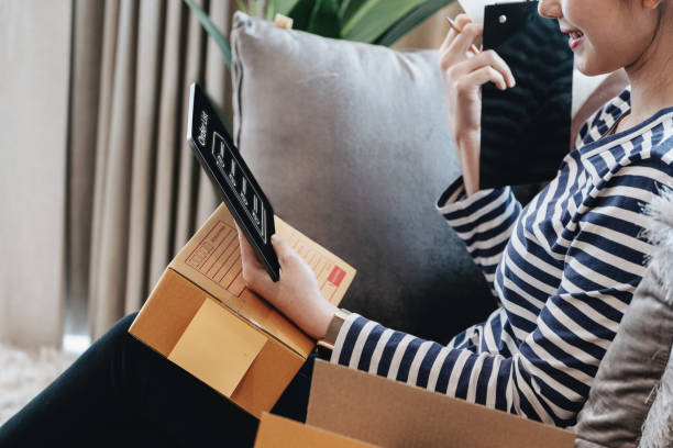 istock Online merchandising business idea, beautiful girl using tablet computer to check orders to deliver parcels to customers according to orders received from customers. 1367679731