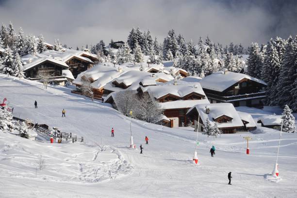 blick auf das skigebiet mit verschneiten chalets und skipisten - mont blanc ski slope european alps mountain range stock-fotos und bilder