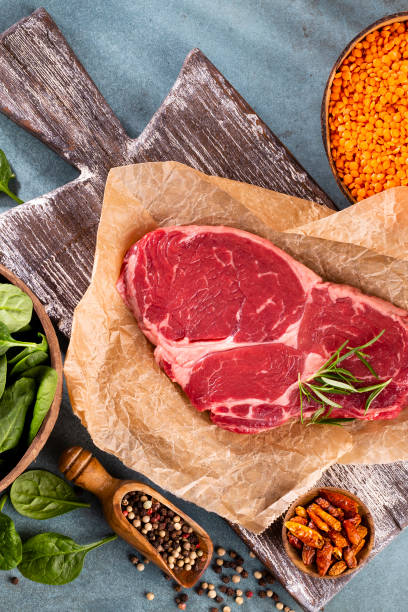 istock Fresh raw rib-eye steak on wooden cutting board. 1367680834