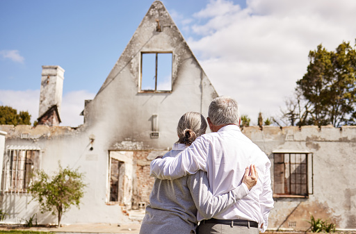 Foto de una pareja de ancianos consolándose mutuamente después de perder su casa por un incendio photo