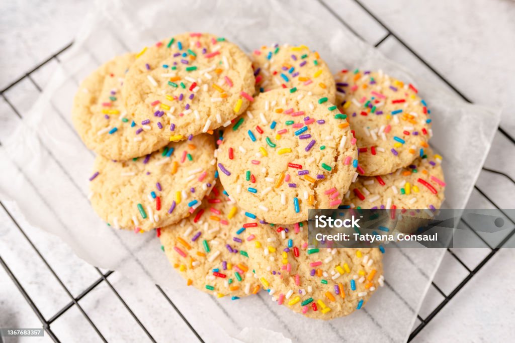 Sugar cookies with rainbow sprinkles Sugar cookies with sprinkles, colorful coffee treat. freshly baked dessert cookies. Cookie Stock Photo