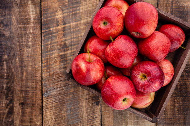 istock Ripe red apples in wooden box. Top view with space for your text. 1367683823
