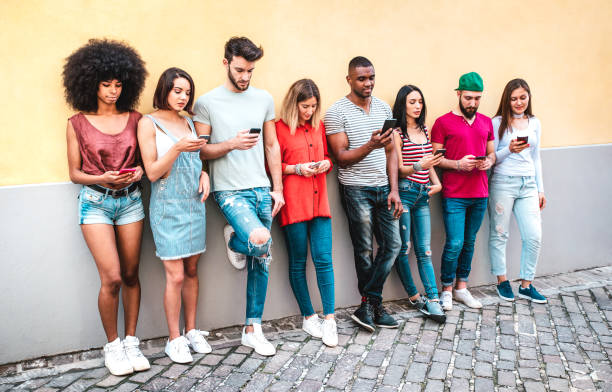 istock Multicultural milenials using smartphone against wall at university college backyard - Young students addicted by mobile smart phone - Technology concept with always connected millenials - Warm filter 1367684533
