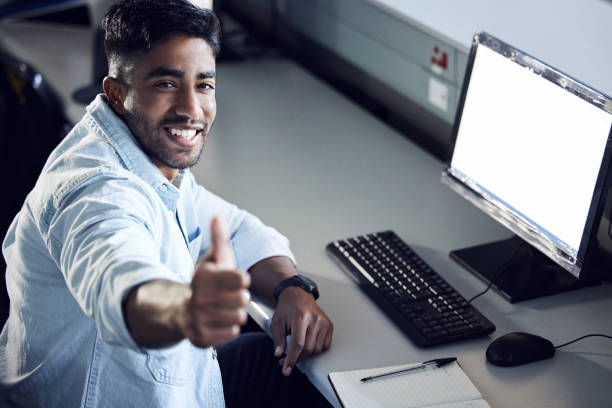 istock Shot of a young man showing thumbs up and using a computer at college 1367685184