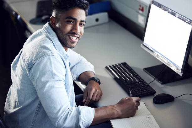 istock Shot of a young man writing in a notebook and using a computer at college 1367685185