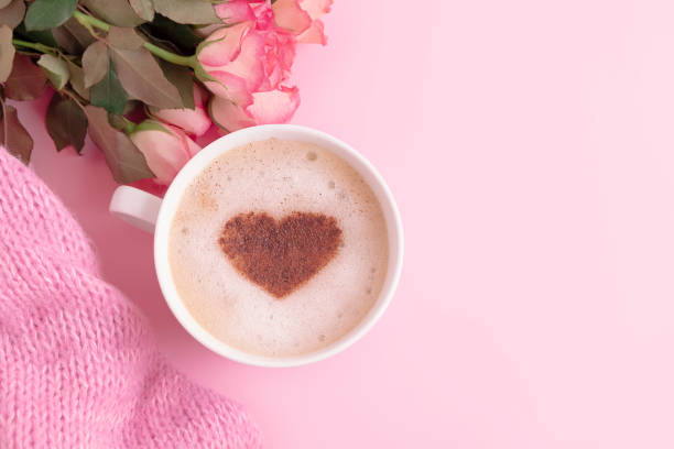 istock Romantic composition with coffee cup with heart on top, flowers and knitted blanket on pastel pink background 1367686453