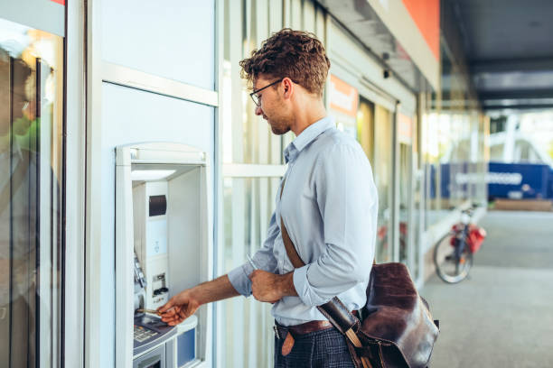 Man is withdrawing cash from an atm machine stock photo