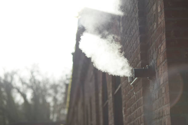 vapor de um tubo foxed em uma parede de tijolos de um prédio antigo. tiro com luz de fundo - foxed - fotografias e filmes do acervo