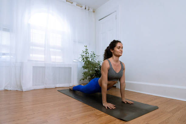 istock Latin woman practicing yoga at home 1367692091